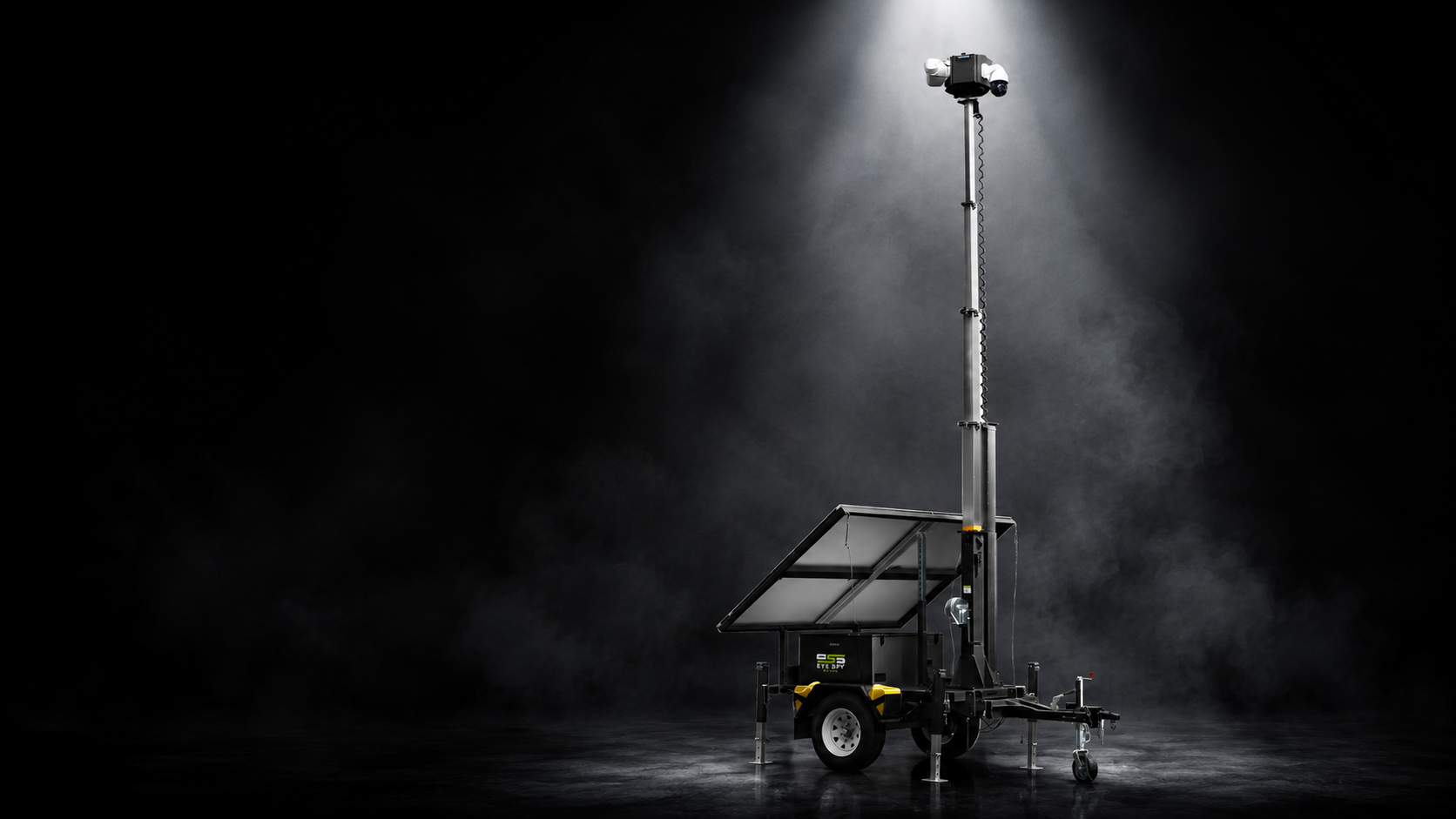 Eye Spy Secure surveillance trailer with extended camera mast and solar panels, photographed in a dark studio with dramatic spotlight