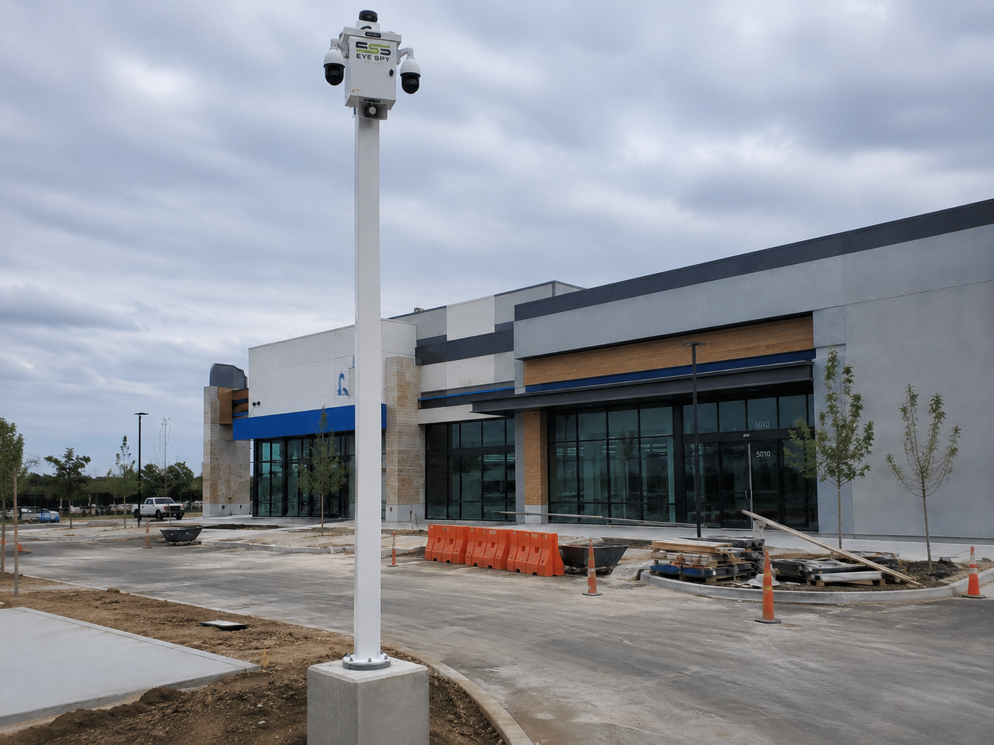 Eye Spy Secure camera enclosure mounted on a pole in a retail parking lot