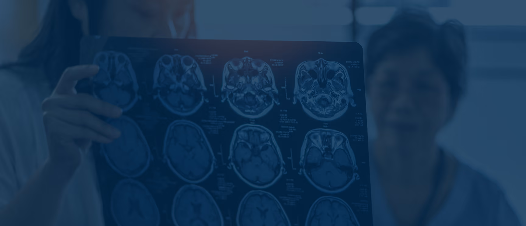 Two medical professionals examining a sheet of brain scan images, focusing on detailed views of brain cross-sections.