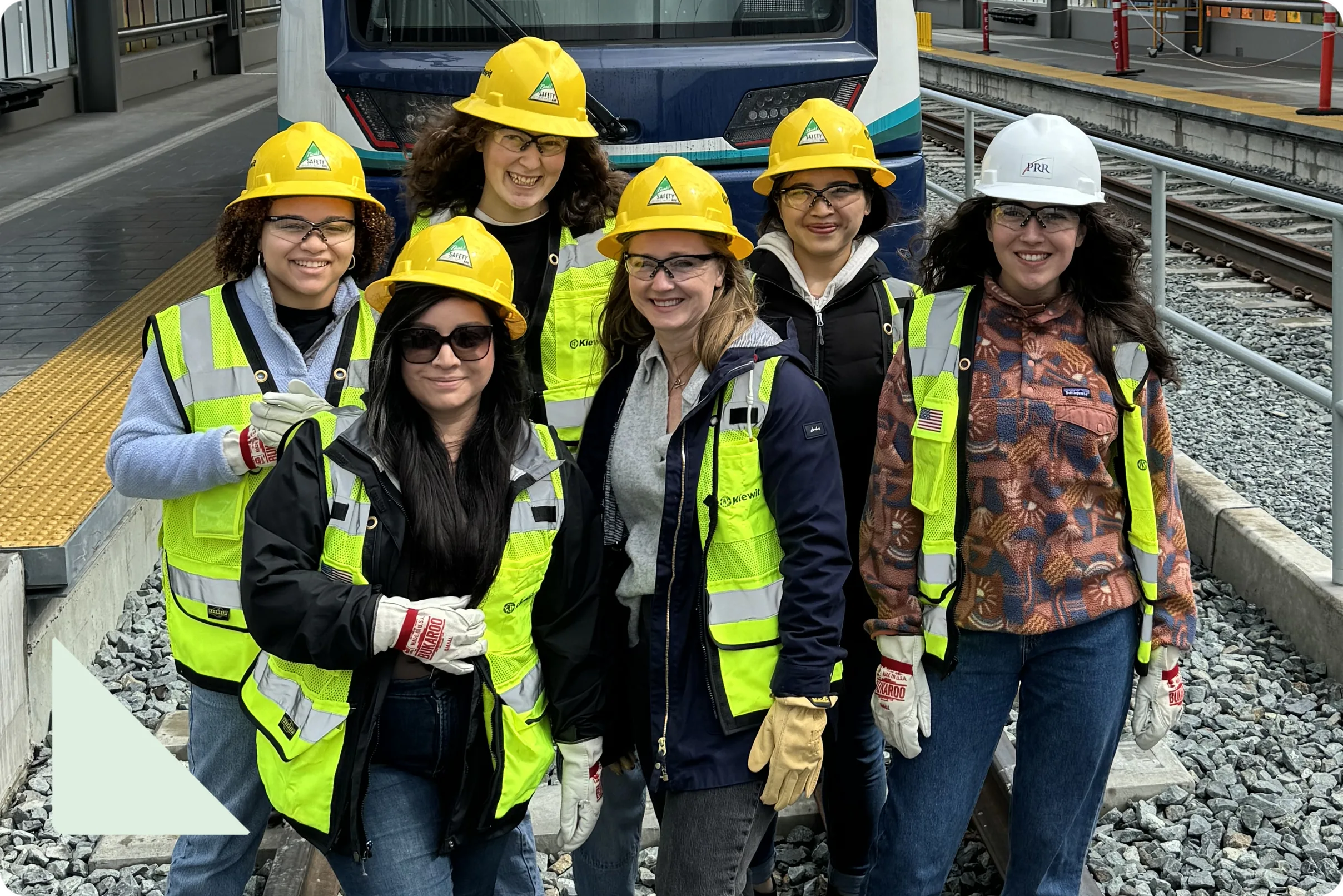 PRR staff in hard hats and high-visibility vests talking together on a construction site