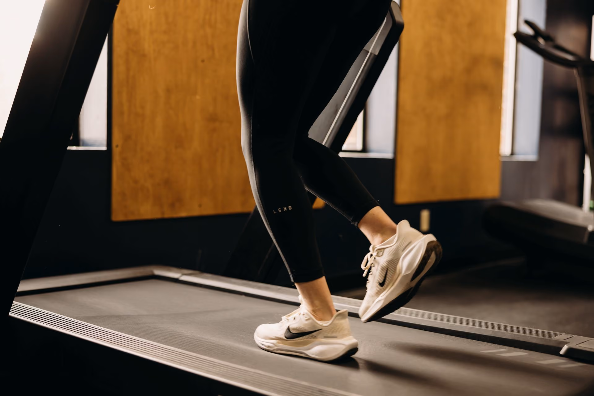 Person walking on a treadmill during a physical therapy session.