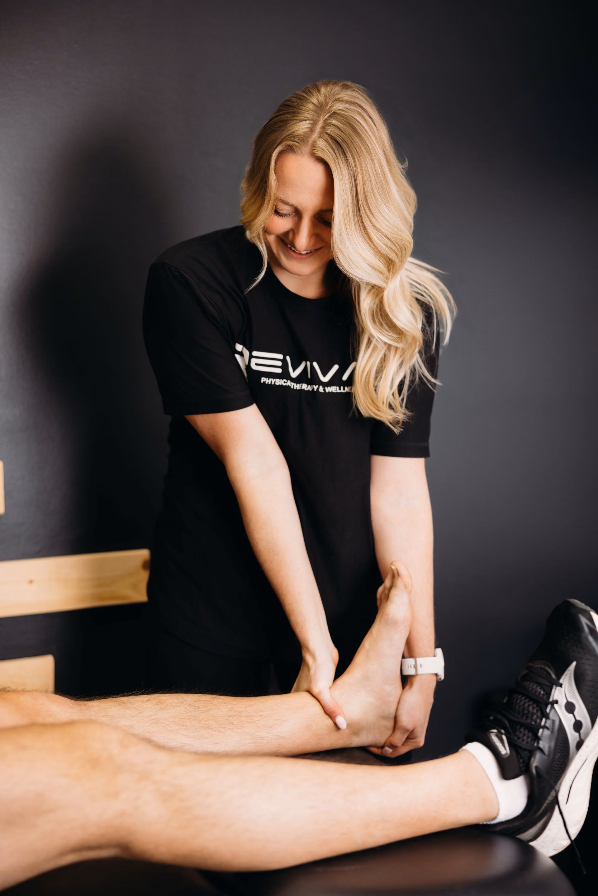 Physical therapist performing manual therapy techniques on a patient’s leg.