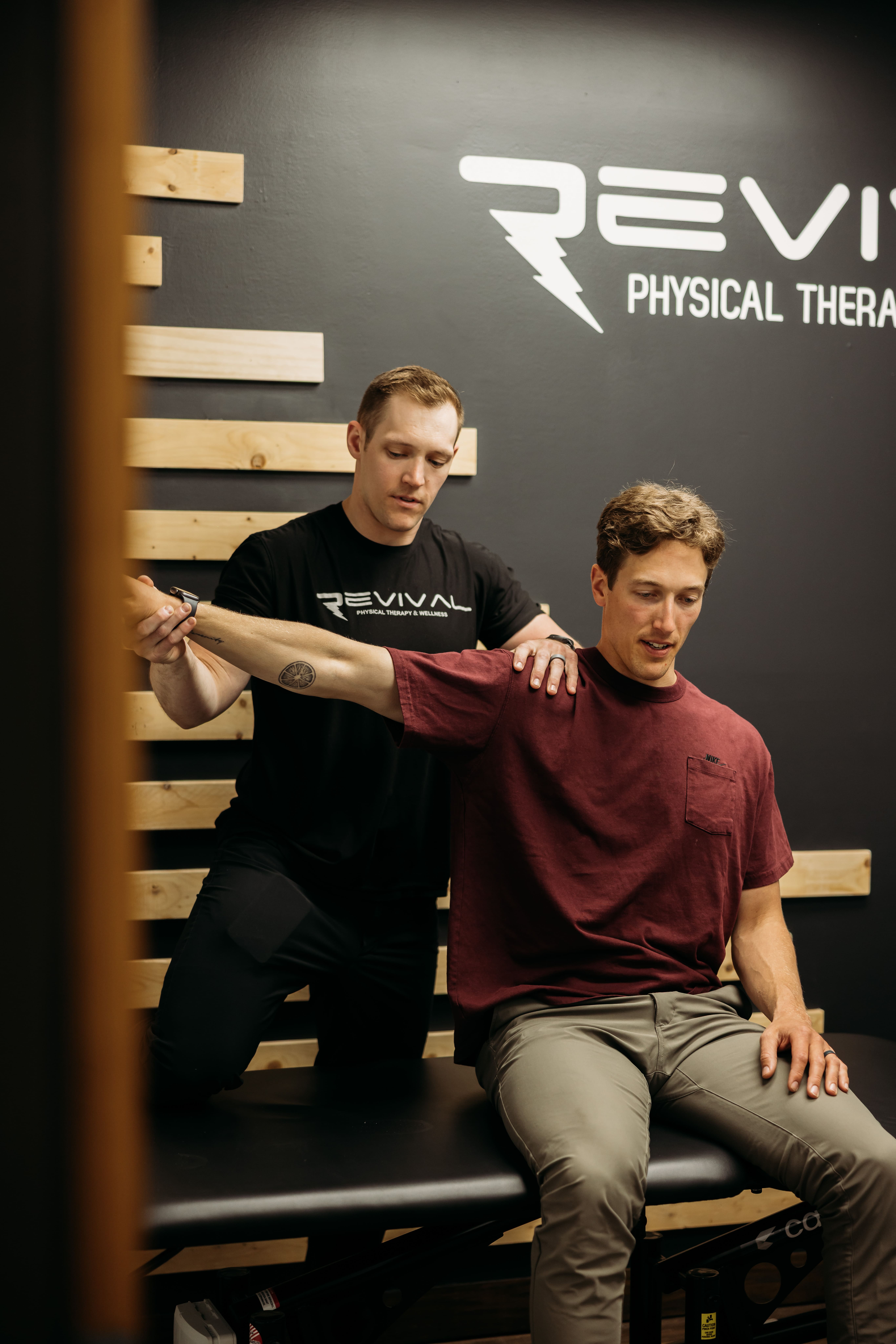 Physical therapist evaluating a patient’s shoulder movement and range of motion.