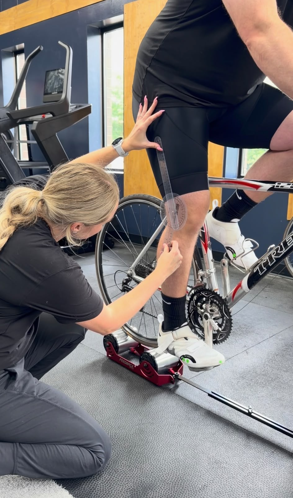 A physical therapist measuring the leg of a patient for a the bike fit.