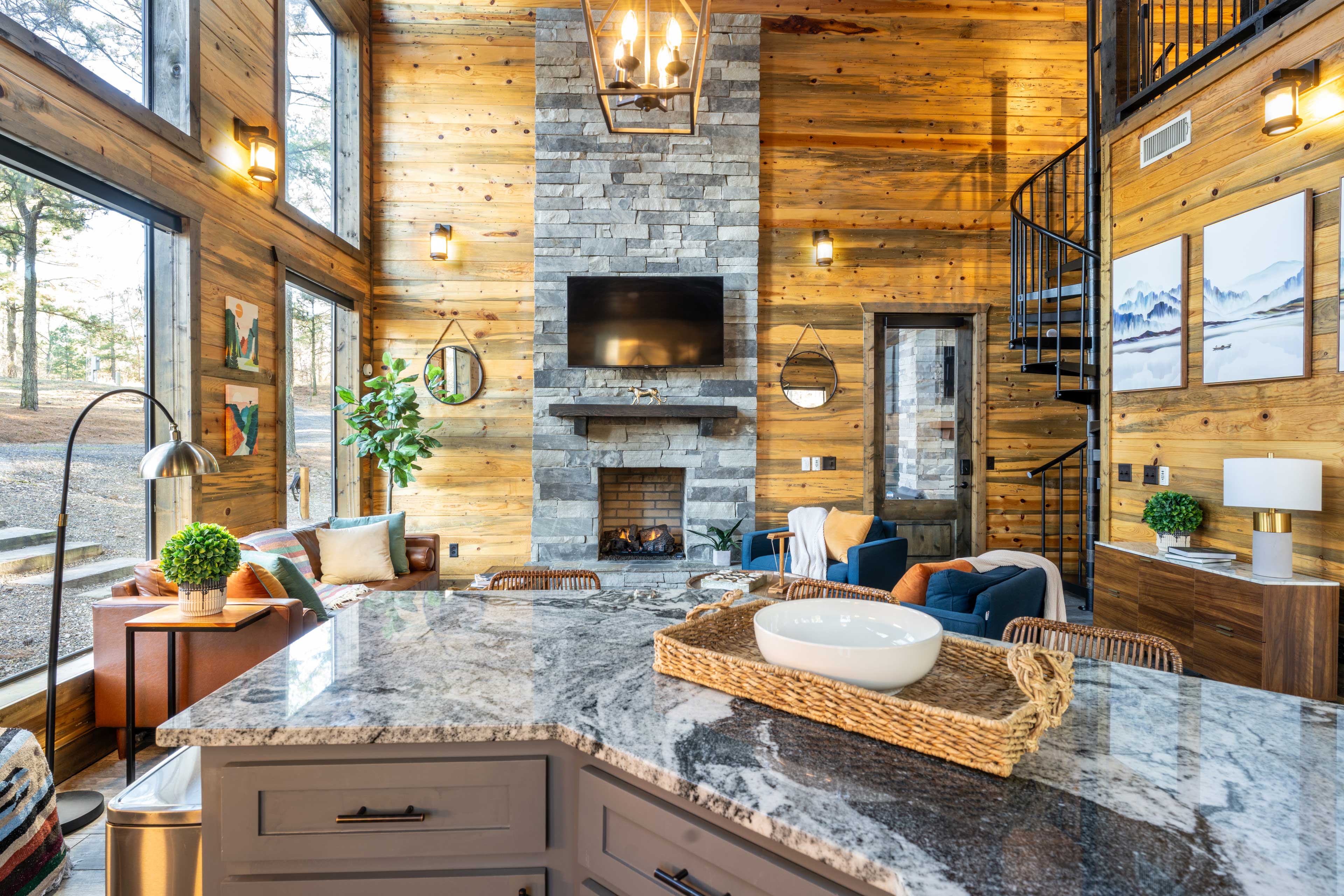 Enjoy the open living space with tall ceilings, gigantic windows, a gas fireplace, a smart TV, and comfortable seating. An island that seats four connects the living and kitchen areas. 