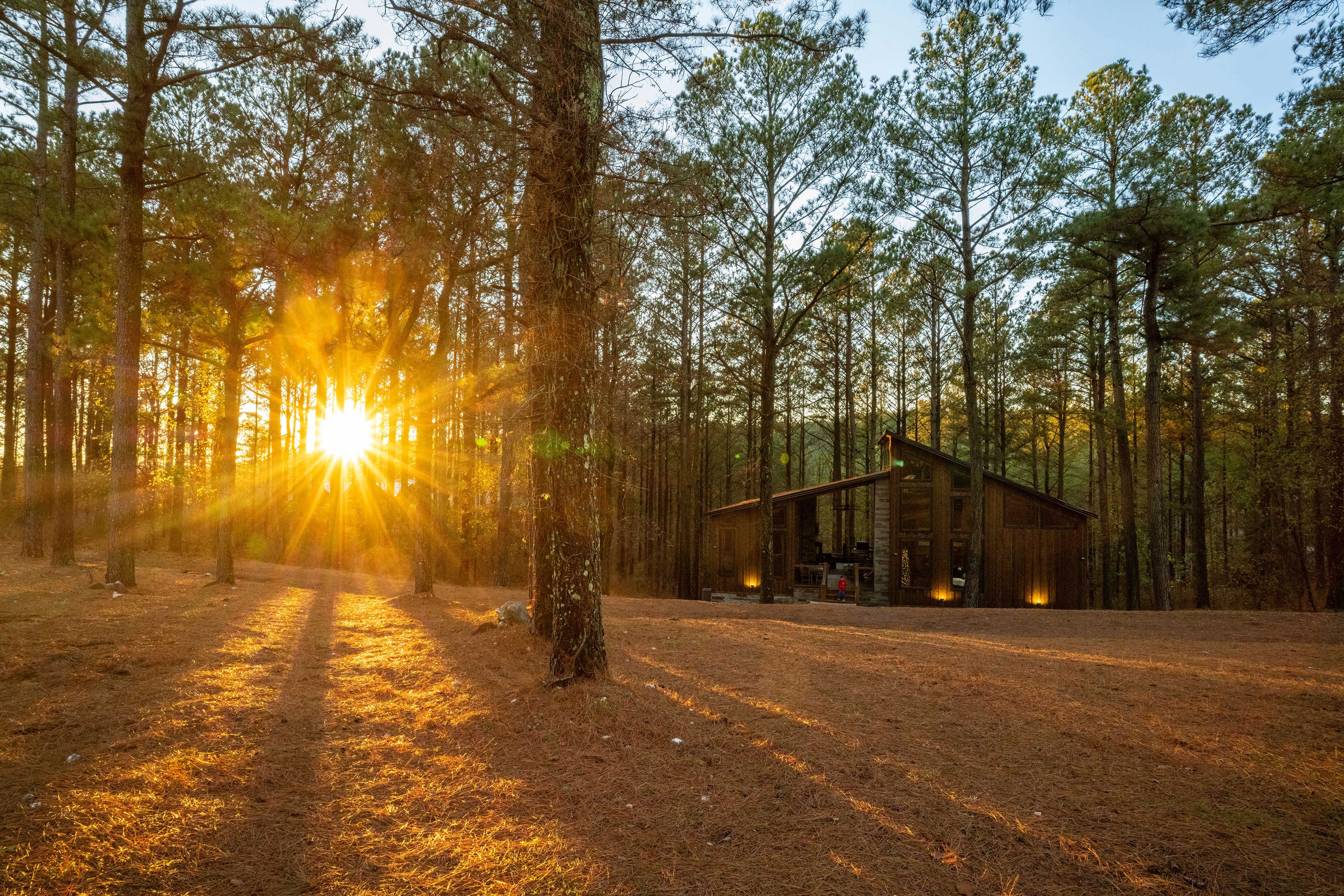 The sun sets behind the cabin on clear evenings and offers a beautiful setting to play bocce ball or just enjoy the scenery. Beautiful uplights and floodlights illuminate the exterior at night.