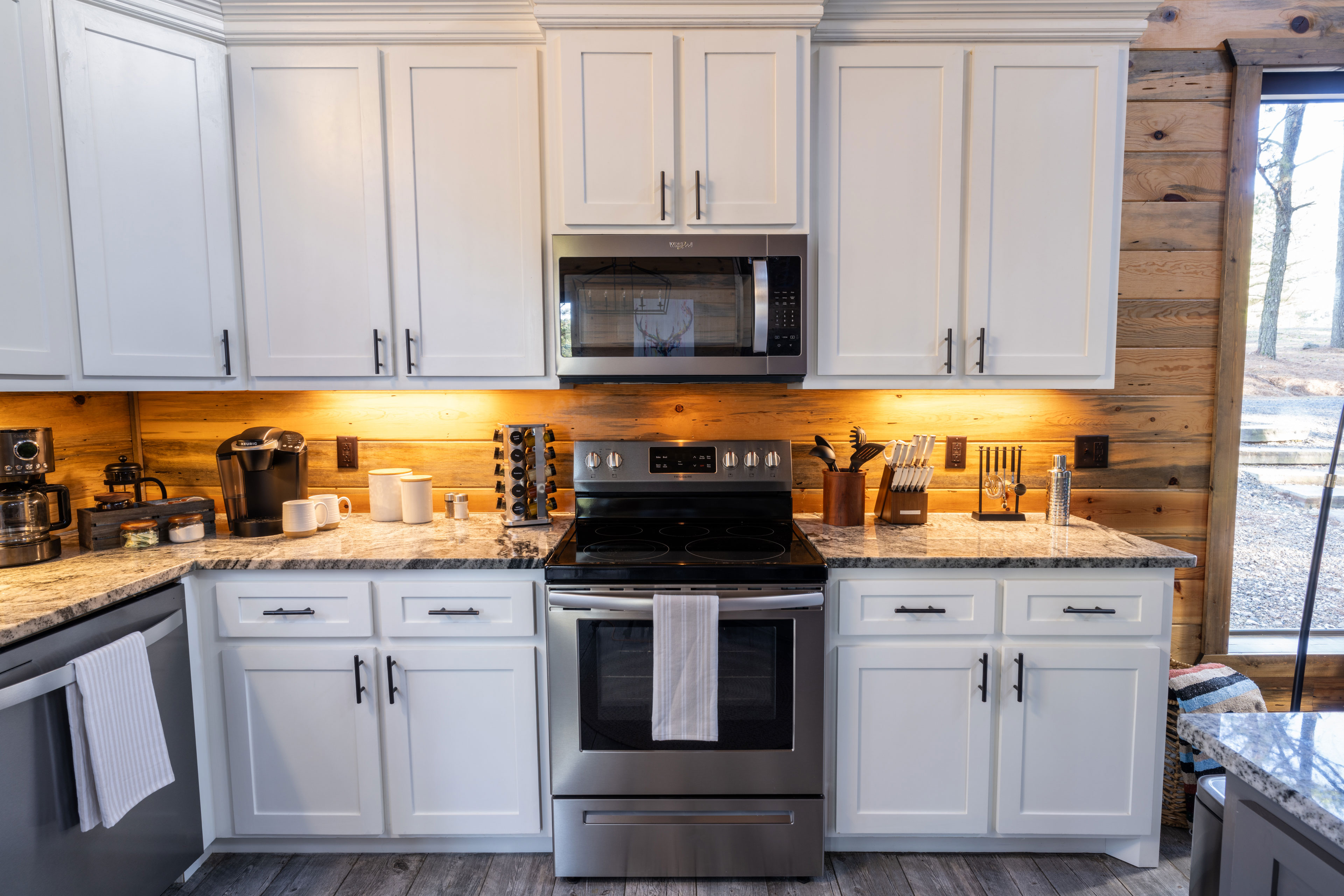 This well-equipped kitchen boasts white cabinetry, modern appliances, and a central island with wicker seating, perfect for socializing while preparing meals. We've stocked the cabinets with sharp knives, tons of utensils, and a spice rack.
