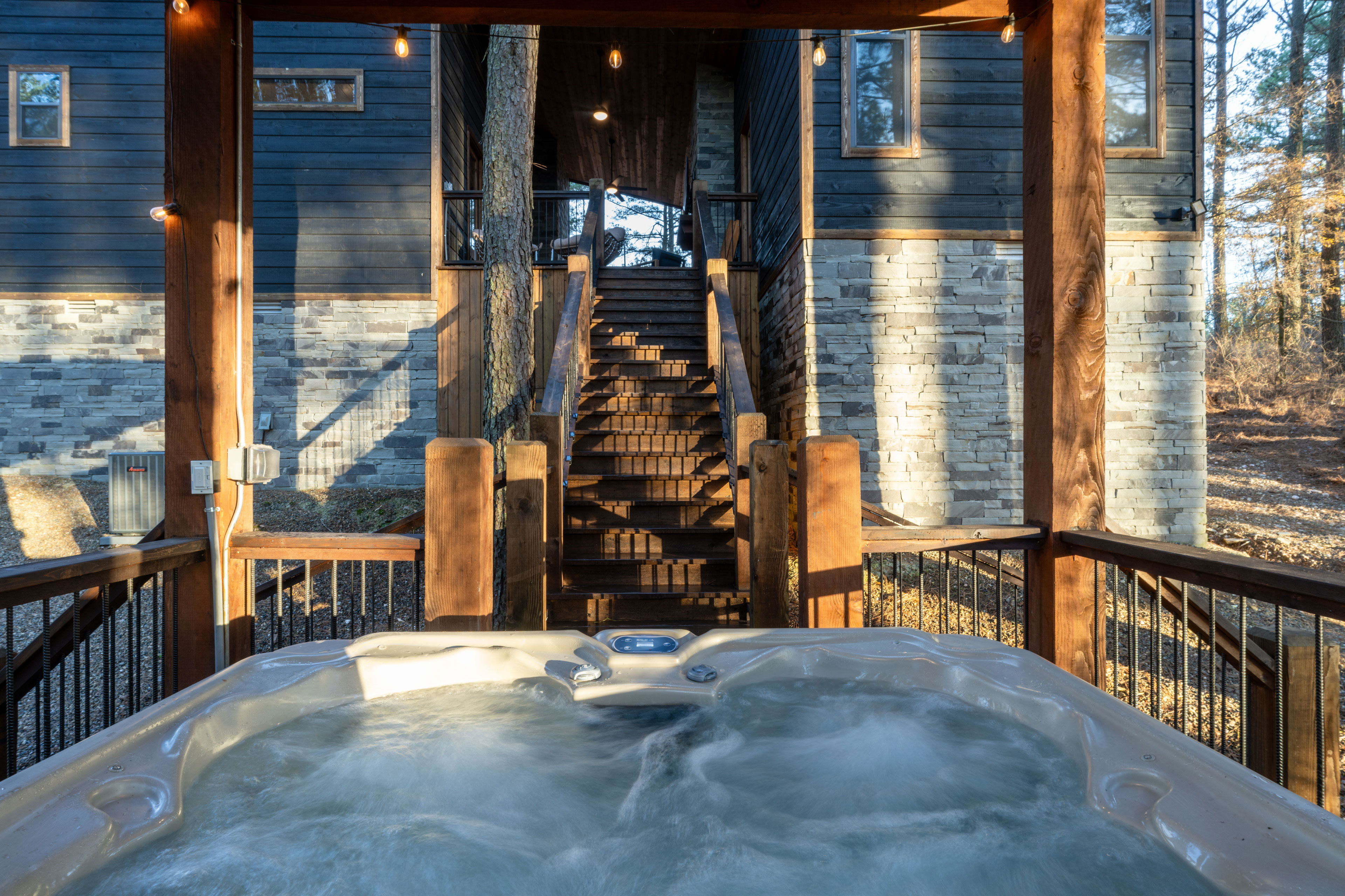 Come down the stairs to soak in the hot tub surrounded by tall pine trees. There's enough space for up to 6 people. 