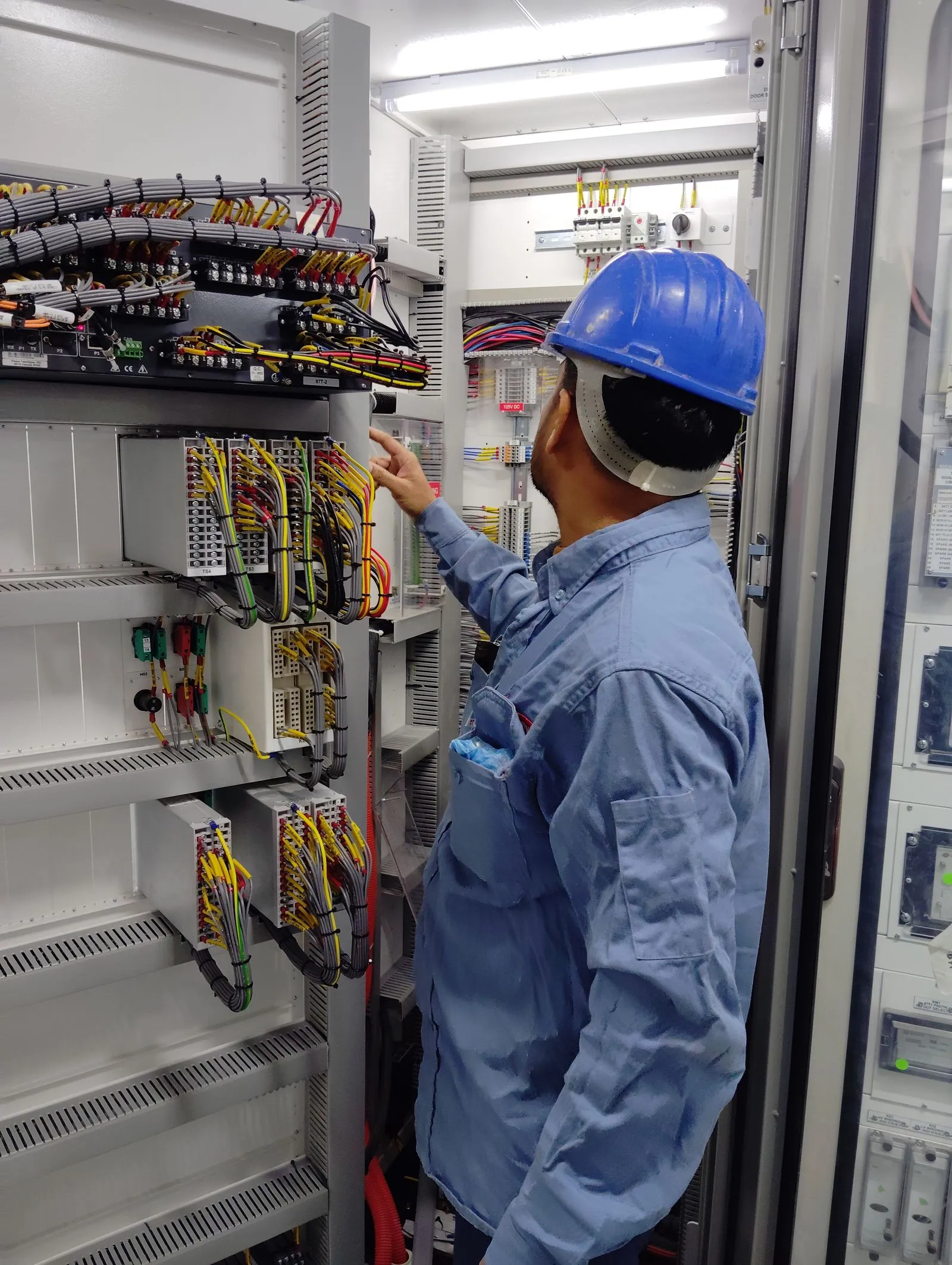Technician inspecting and servicing a commercial control panel