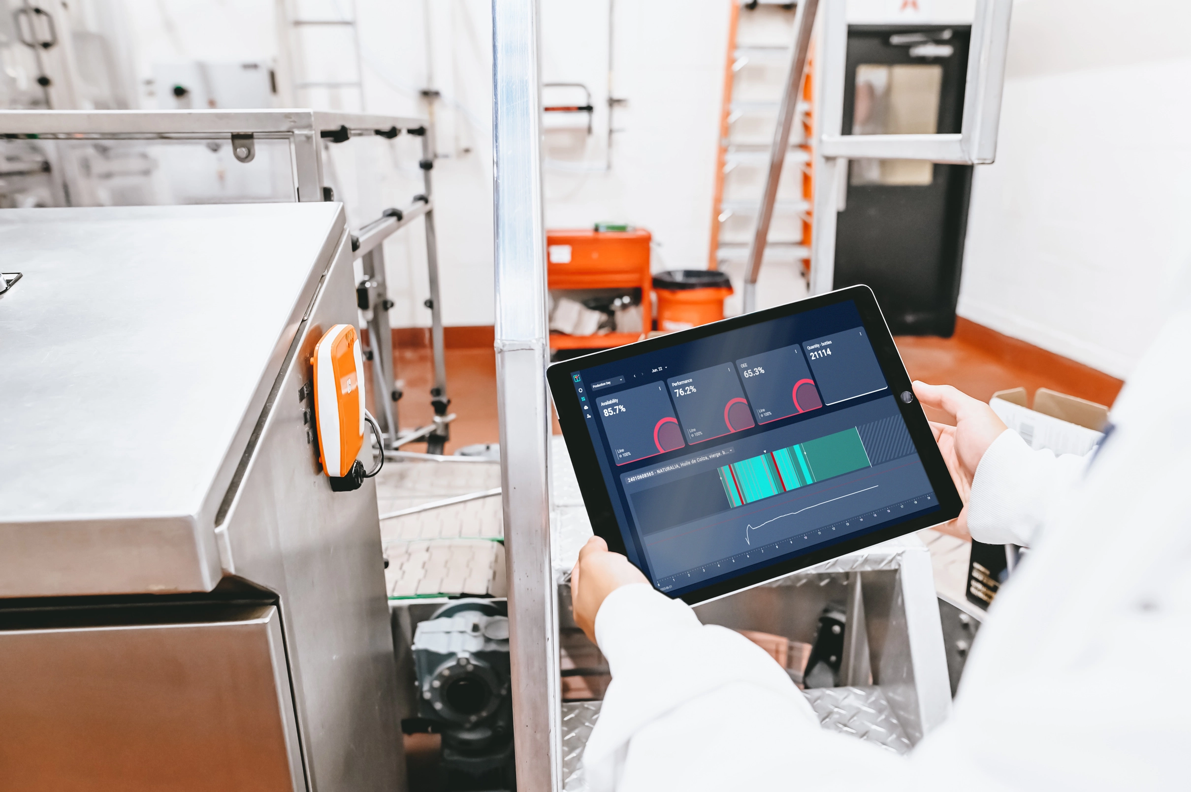 A frontline factory worker interacting with Tile+ real-time production monitoring dashboard on an iPad.