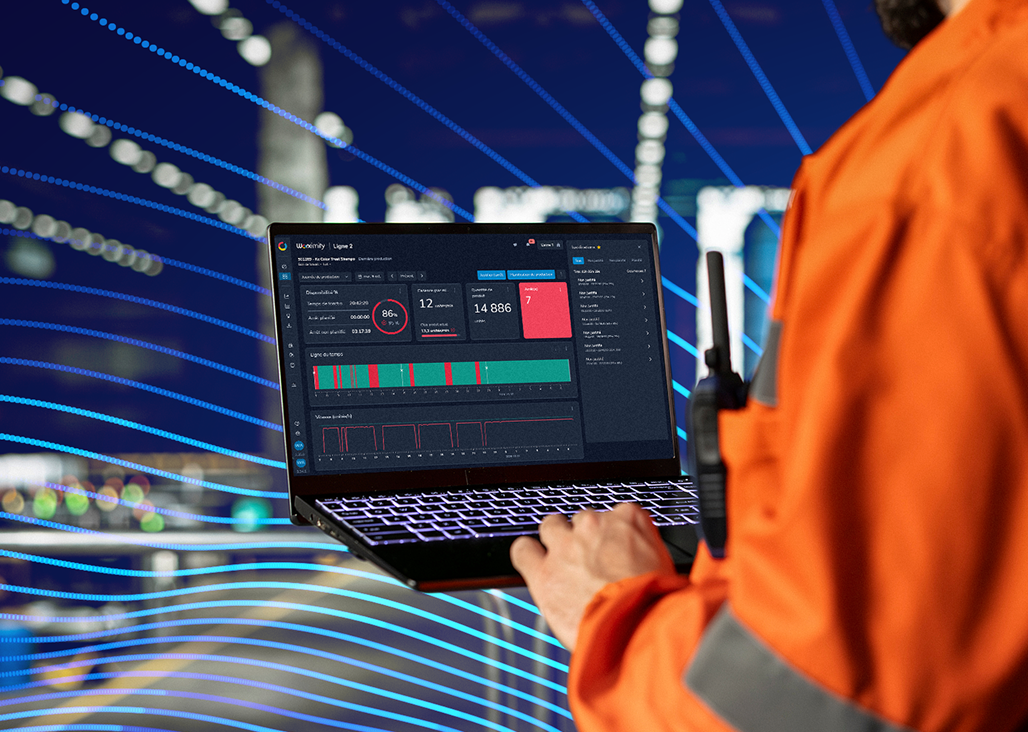 Employé consultant un tableau de bord Worximity sur ordinateur portable en usine.