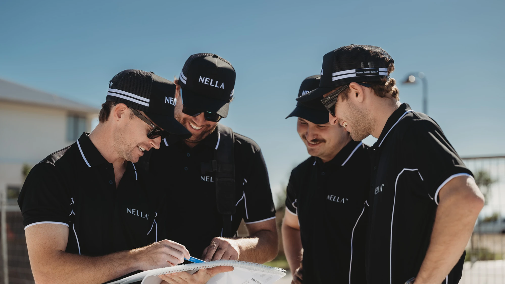 Nella team reviewing building plans together on site during a residential construction project.