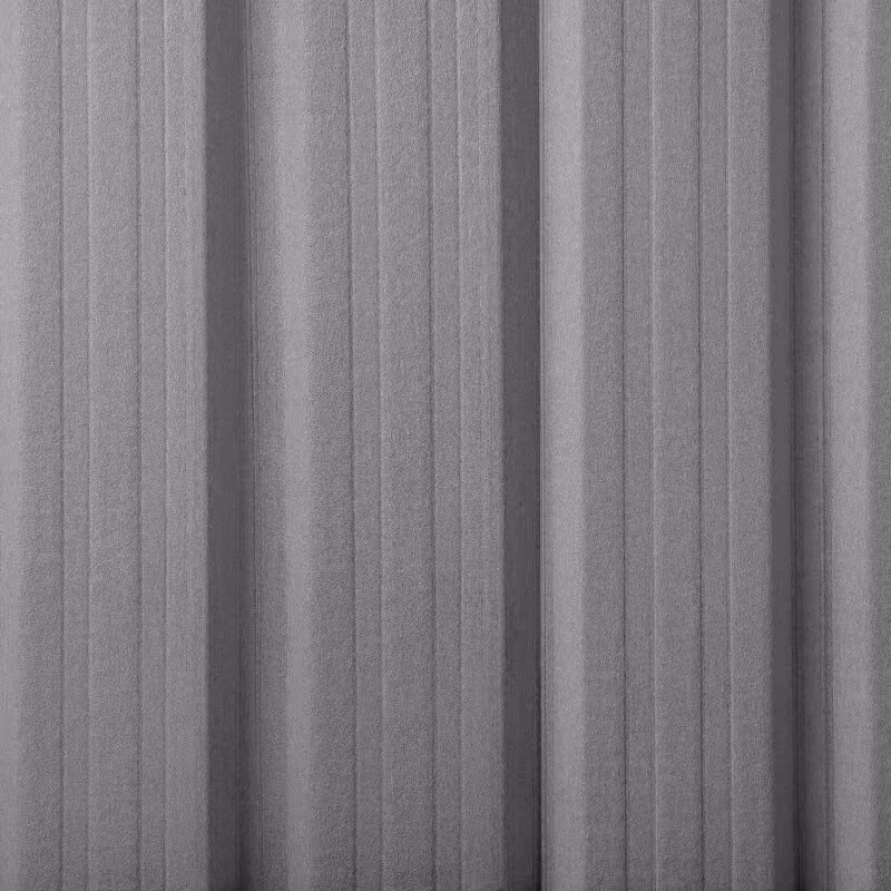 Close-up of a grey corrugated metal surface with vertical ridges and shadows emphasizing its texture.