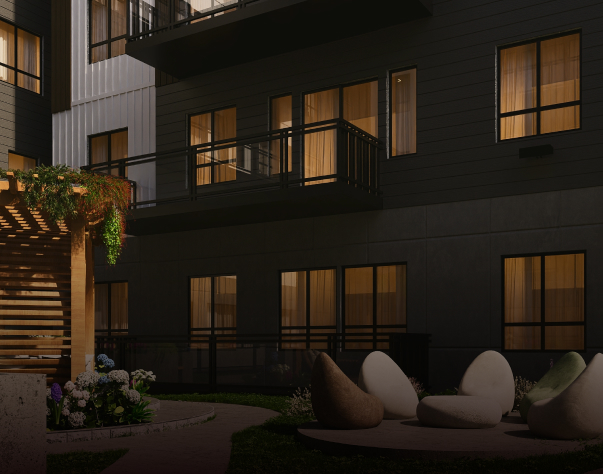 Night view of modern apartment building exterior with lit windows and outdoor seating area with bean bags.