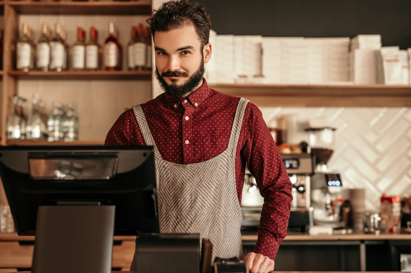 Restaurant staff member behind the counter of a busy café.