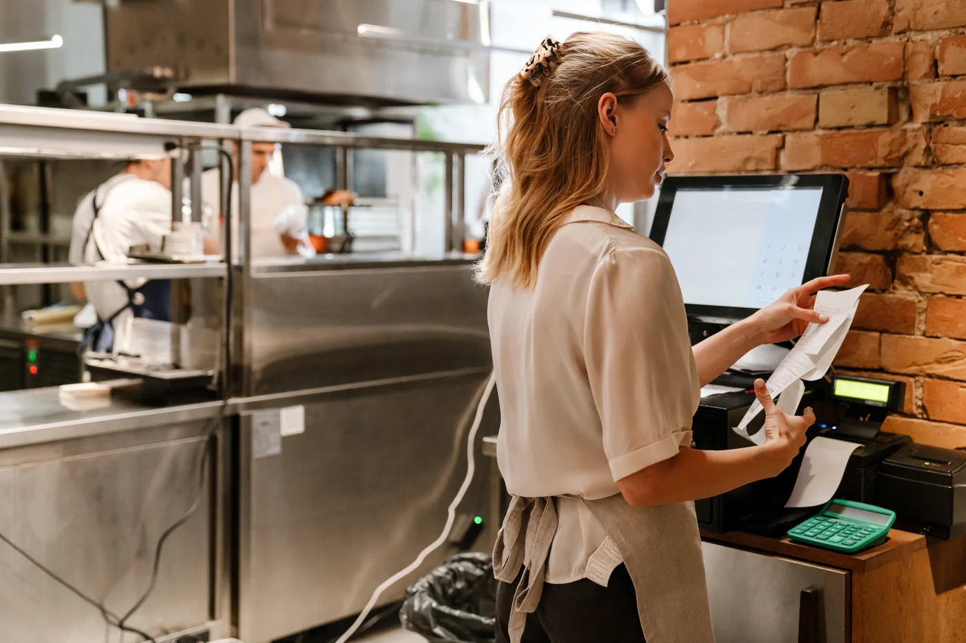 Restaurant staff member closing out a check at the POS terminal.