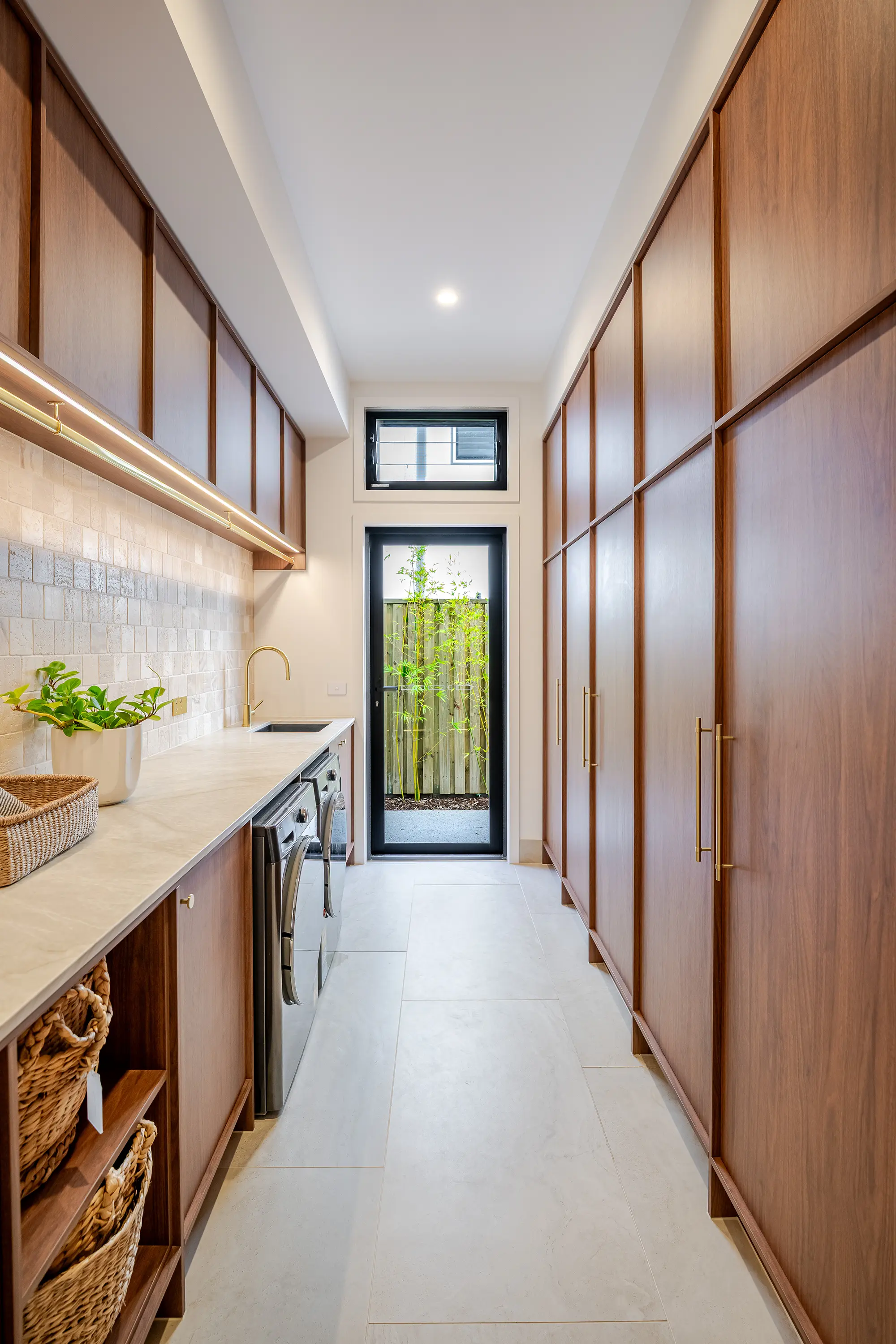 Laundry with timber cabinetry inside Thalassa by Nella