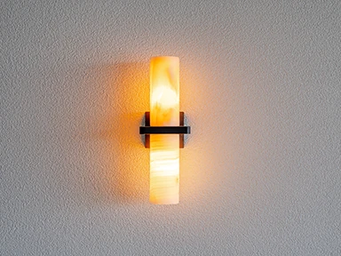 Architectural wall light detail with warm illumination on a textured wall in the Claro Signature Range home.
