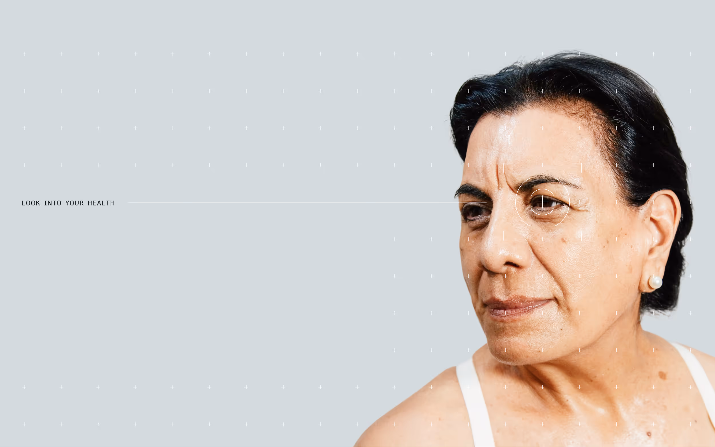 Portrait of a mature woman with a focused expression and eye target graphic over her right eye on a gray background.