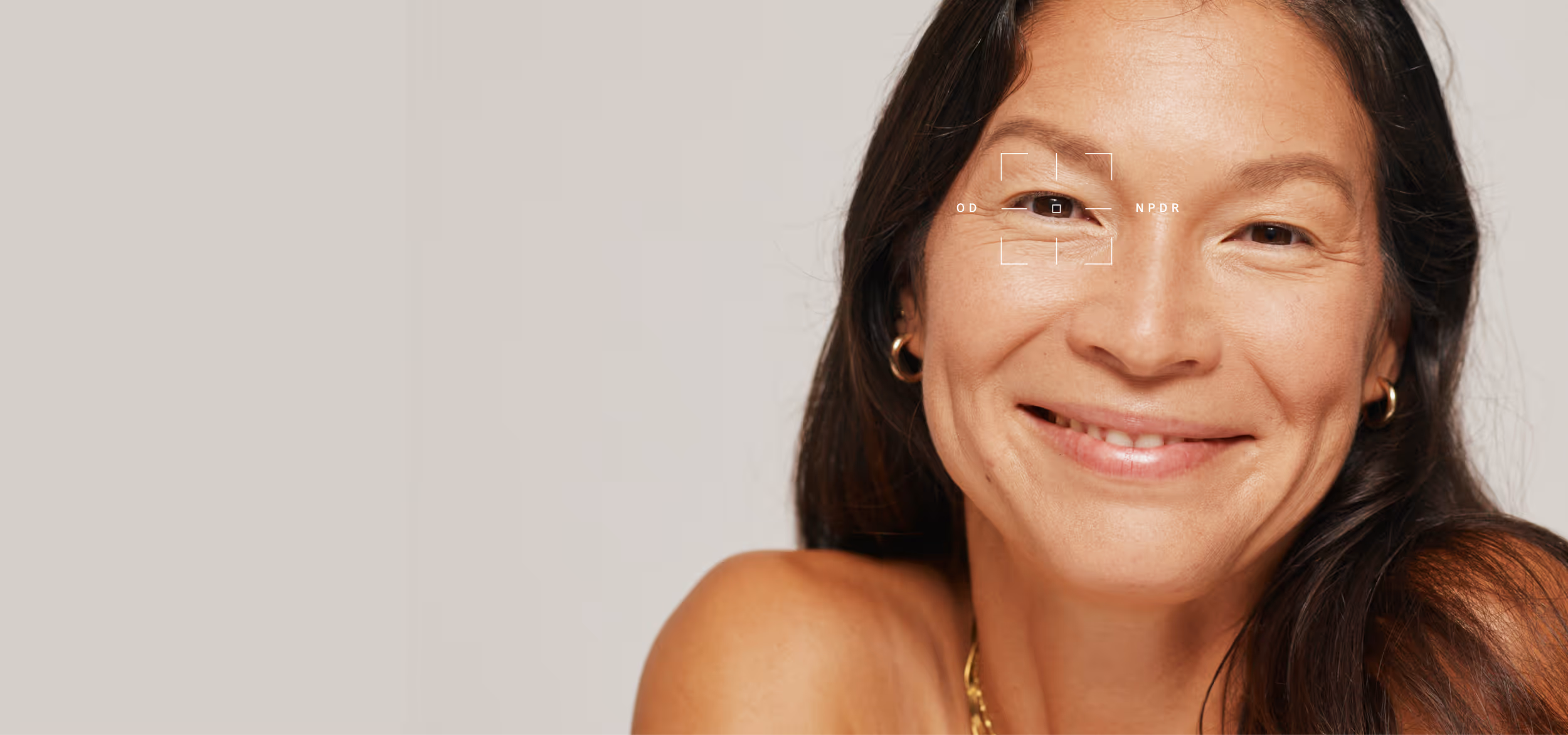 Smiling woman with long dark hair wearing gold hoop earrings and a gold chain necklace against a neutral background.