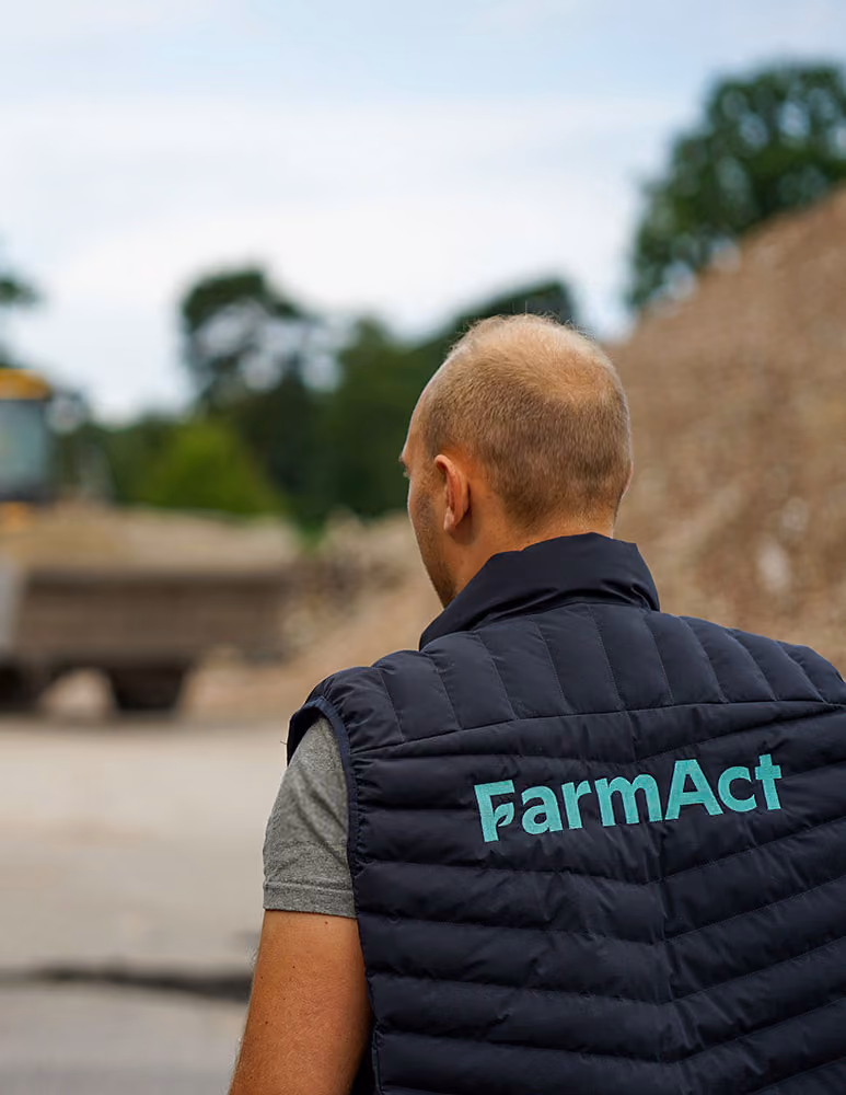 Mitarbeiter im FarmAct-Weste auf dem Hof eines Lohnunternehmens