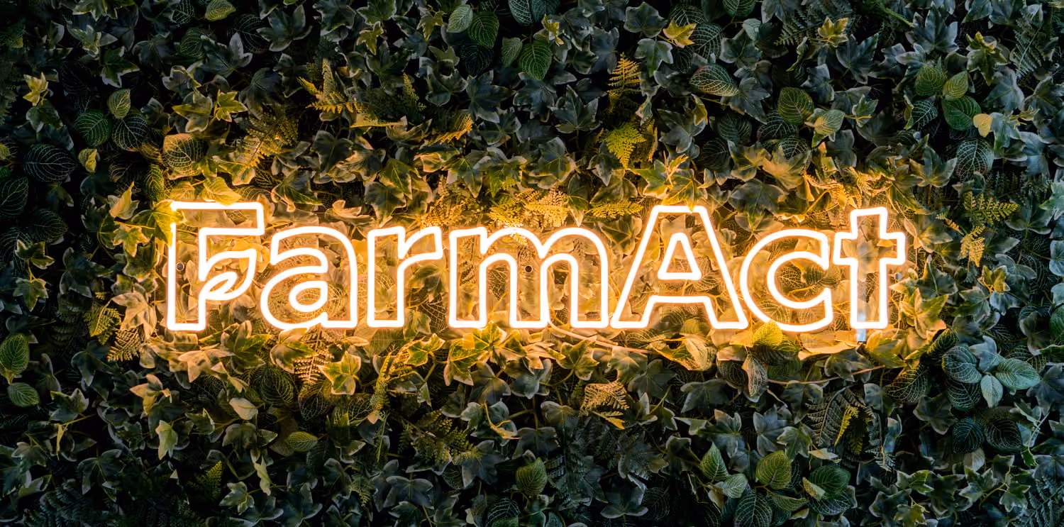 FarmAct Schriftzug als Leuchtschild an der begrünten Wand im Büro