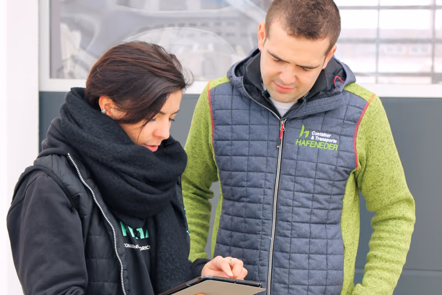 Mitarbeitende und Kunde stimmen einen Auftrag per Tablet im Freien ab