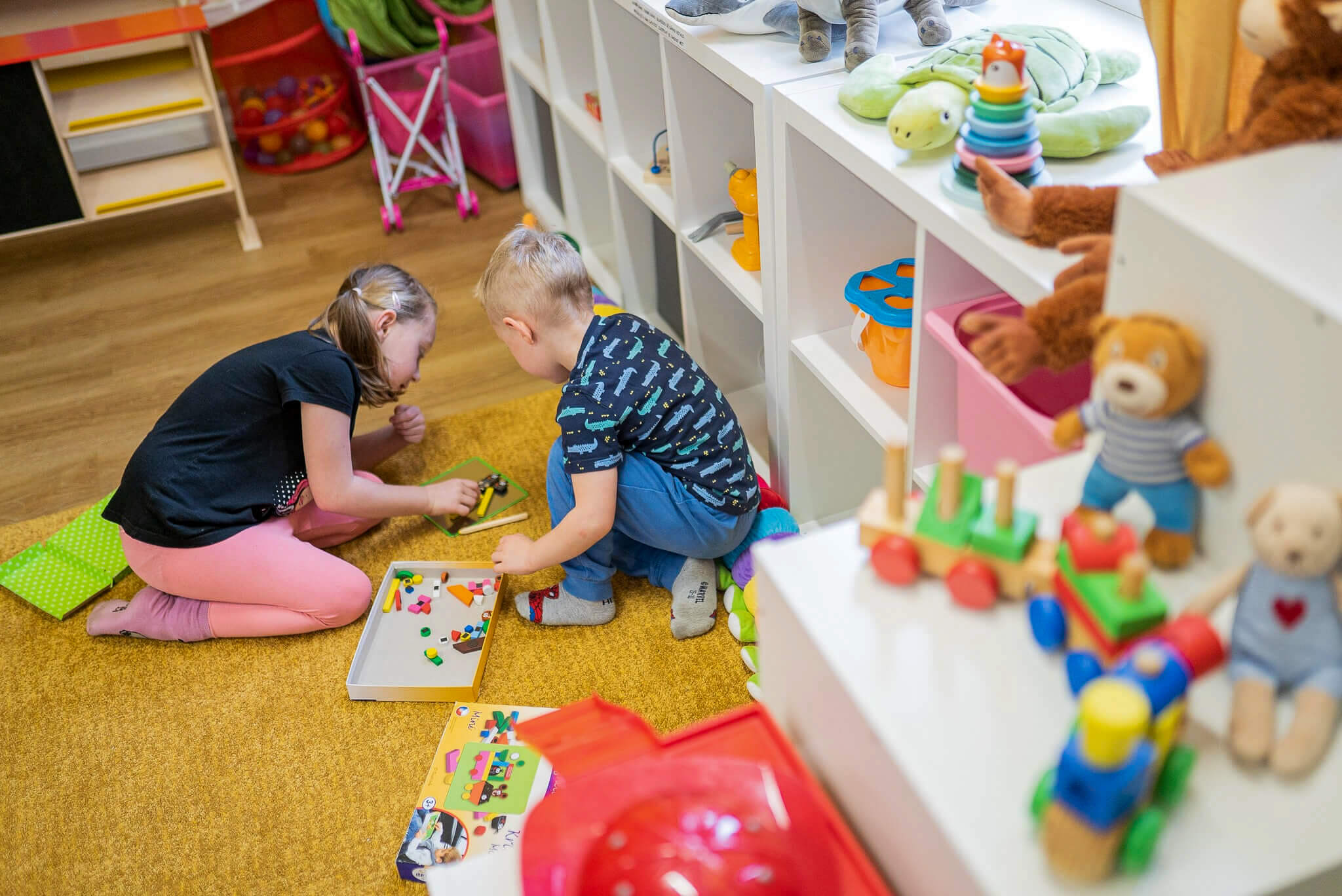 Děti skládající obrázek ze dřevěných předmětů