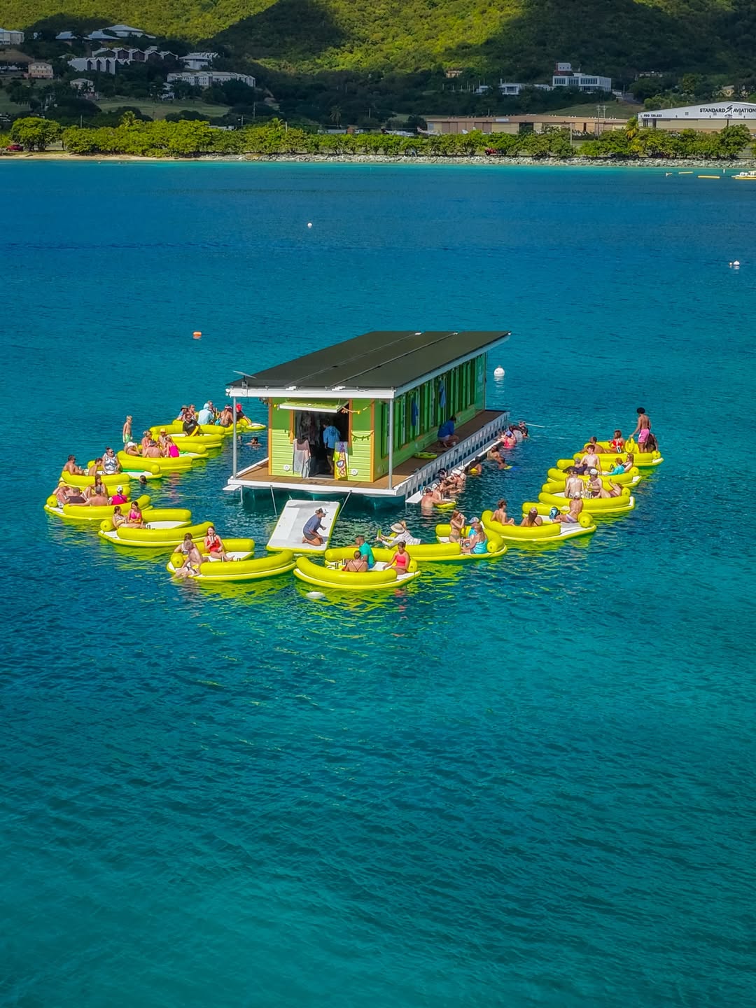Passenger boat named Reef Surfari cruising on blue water near a green rocky island.