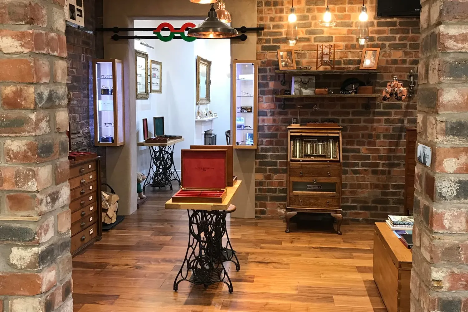 Vintage optician shop interior with wooden floors, brick walls, display cases, and antique equipment.