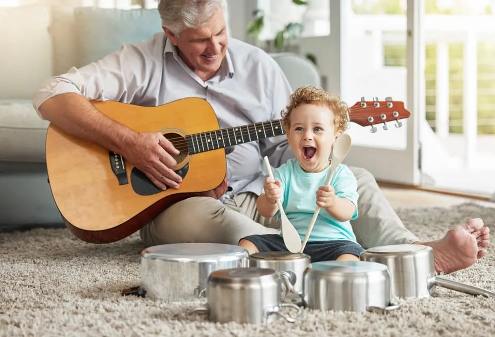 Father playing guitar for his toddler