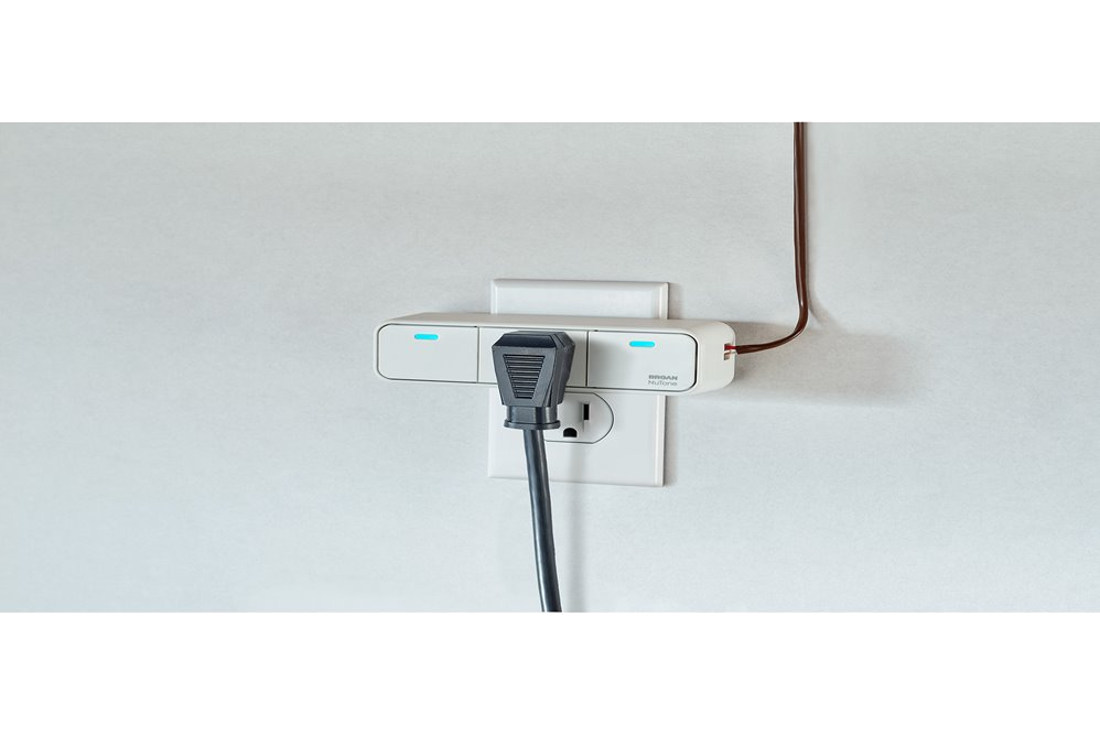 Overture Smart Plug in an outlet with a cord plugged into it