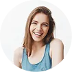 Smiling woman with brown hair wearing a blue tank top against a white background.