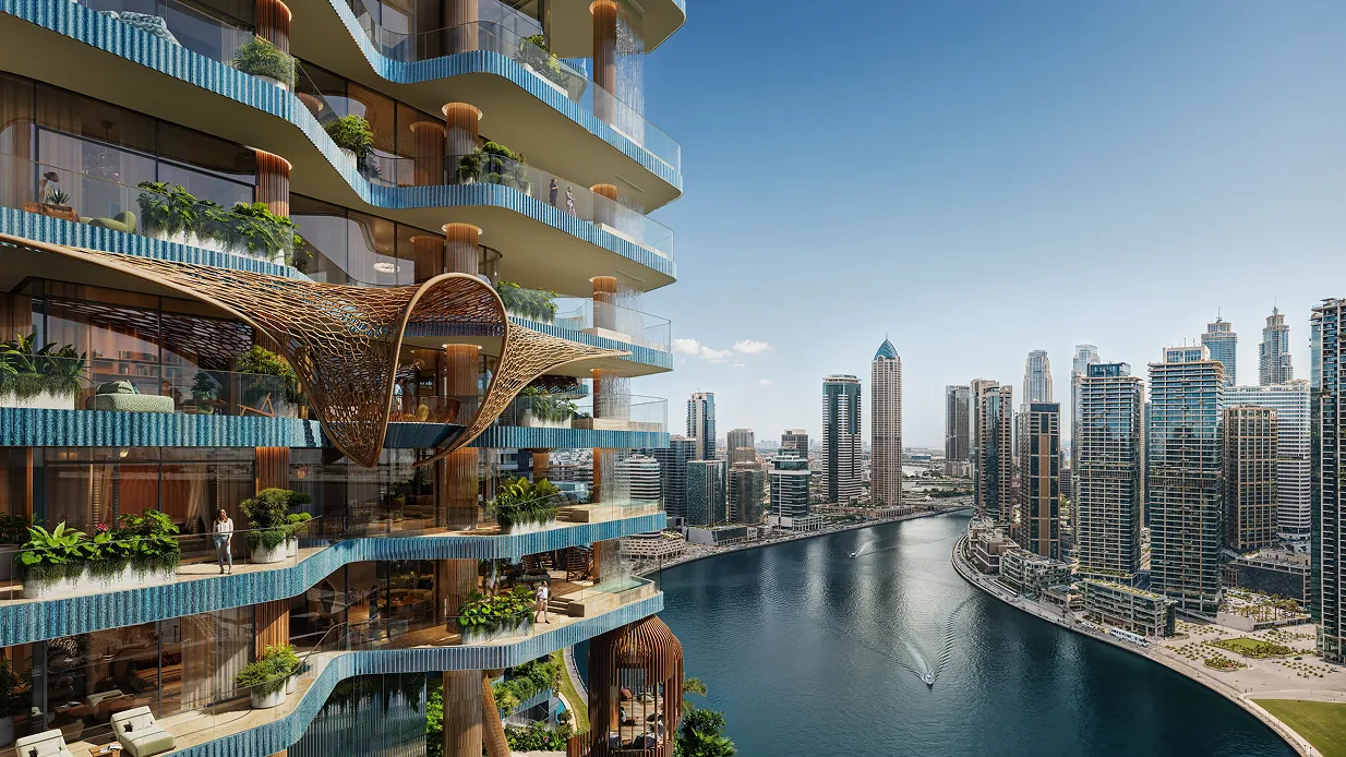 Modern waterfront skyscraper with curved balconies and blue accents overlooking a city river.