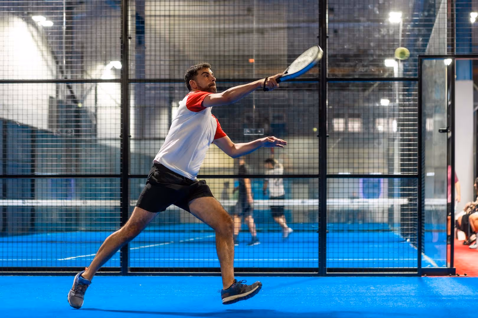 Image of male individual playing padel on padel court