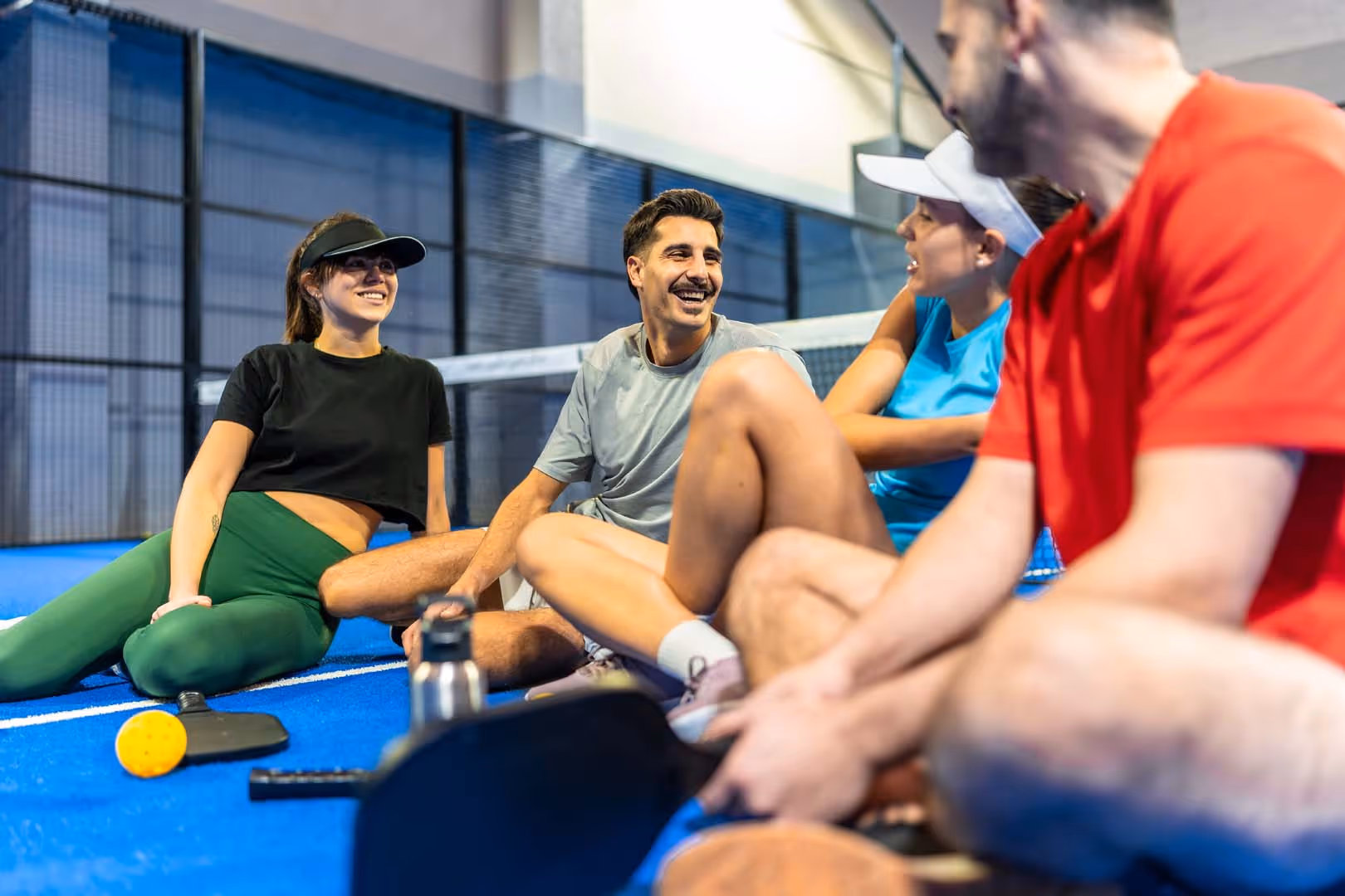 Image of group of friends on padel court, smiling together