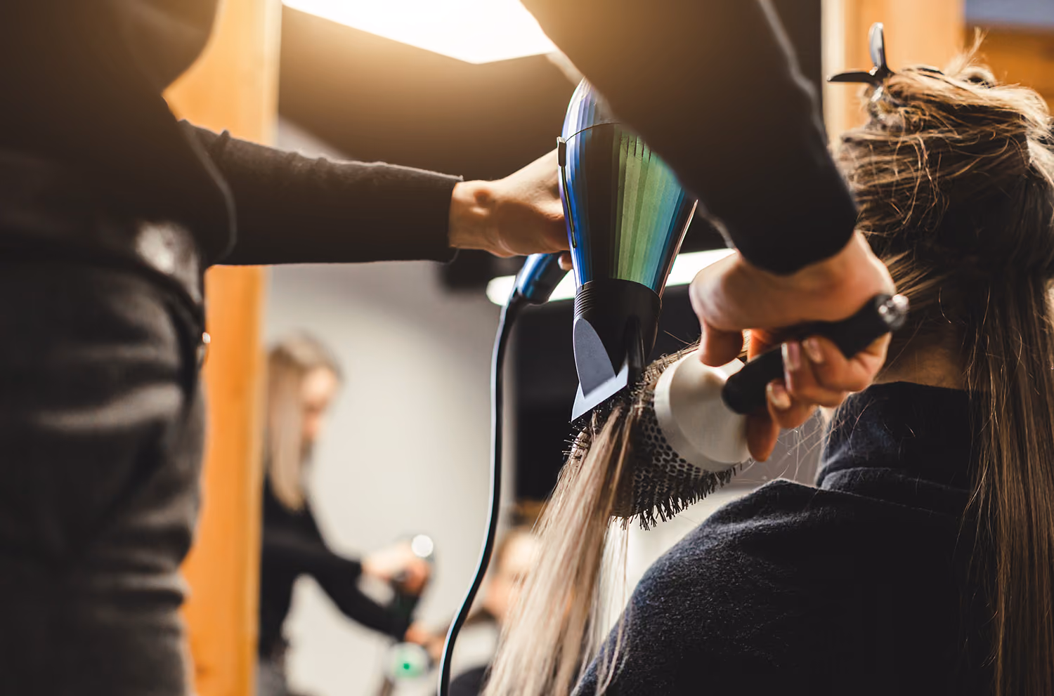 A close up of a lady having a hair cut and blow dry