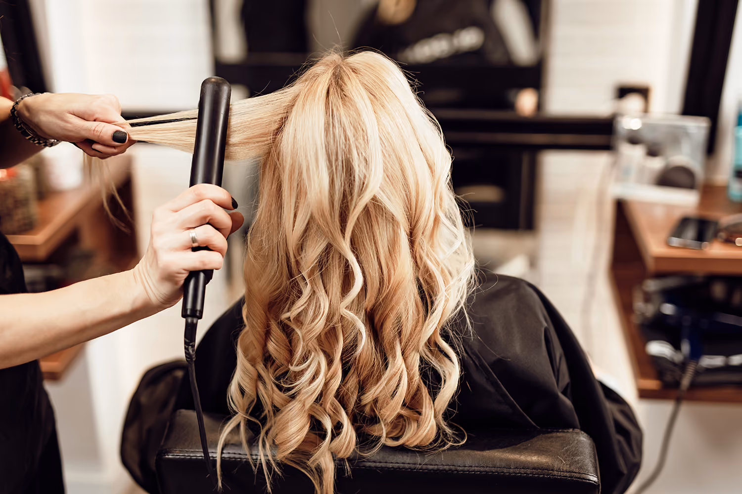 The back of a ladies head having her hair curled