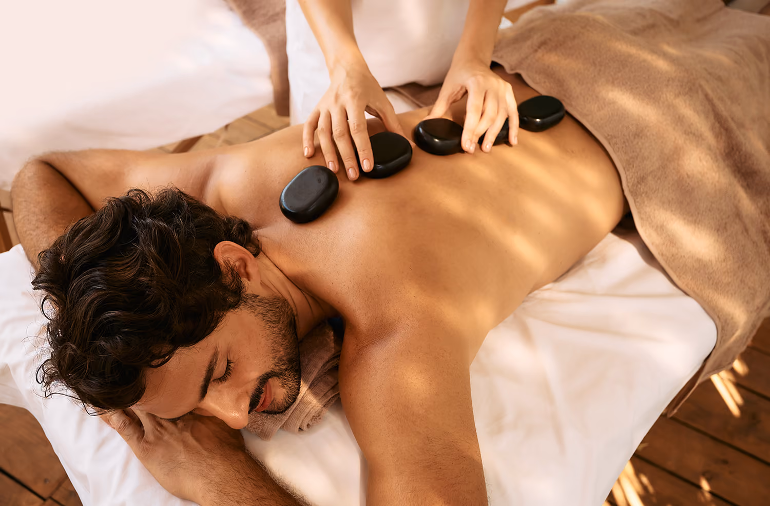A man receiving a hot stone massage
