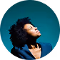 Woman with curly hair looking upward against a teal background.