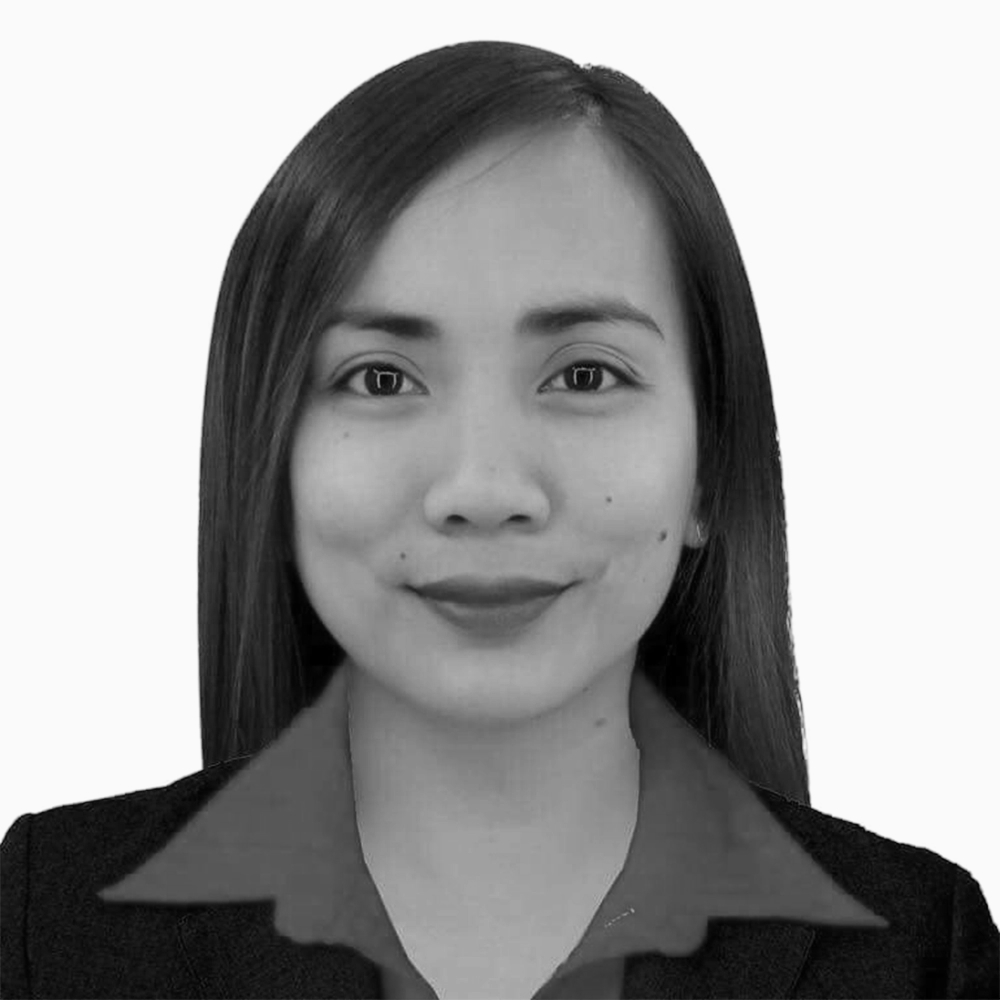 Professional black and white headshot of Angelina, Sales Development Representative at Key Outreach, wearing a collared shirt and blazer while posing against a light gray background.