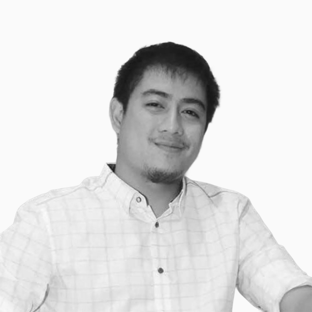 Professional black and white headshot of Almedes, Sales Operations Representative at Key Outreach, wearing a light checkered button-up shirt while posing against a light gray background.