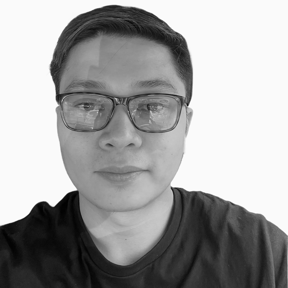 Professional black and white headshot of Butch, Sales Development Manager at Key Outreach, wearing glasses and a dark crew neck shirt while posing against a light gray background.