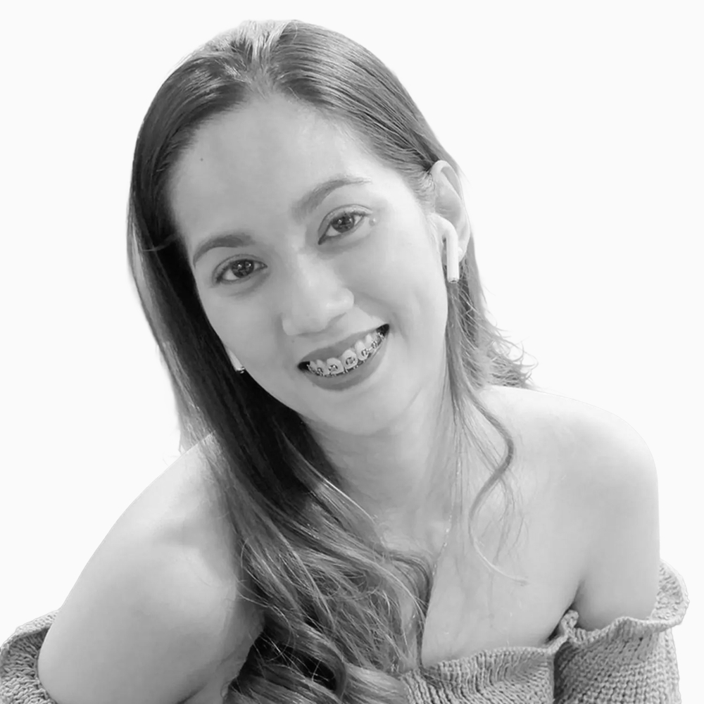 Professional black and white headshot of Gillianne, Sales Development Representative at Key Outreach, smiling while wearing an off-shoulder knit top and wireless earbuds against a light gray background.