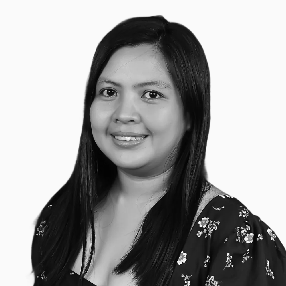 Professional black and white headshot of Jeraldine, Sales Development Manager at Key Outreach, smiling while wearing a dark floral blouse against a light gray background.