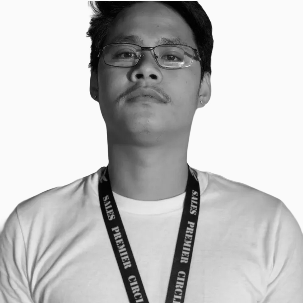 Professional black and white headshot of Raph, Business Development Representative at Key Outreach, wearing glasses, a white crew neck shirt, and a lanyard while posing against a light gray background.