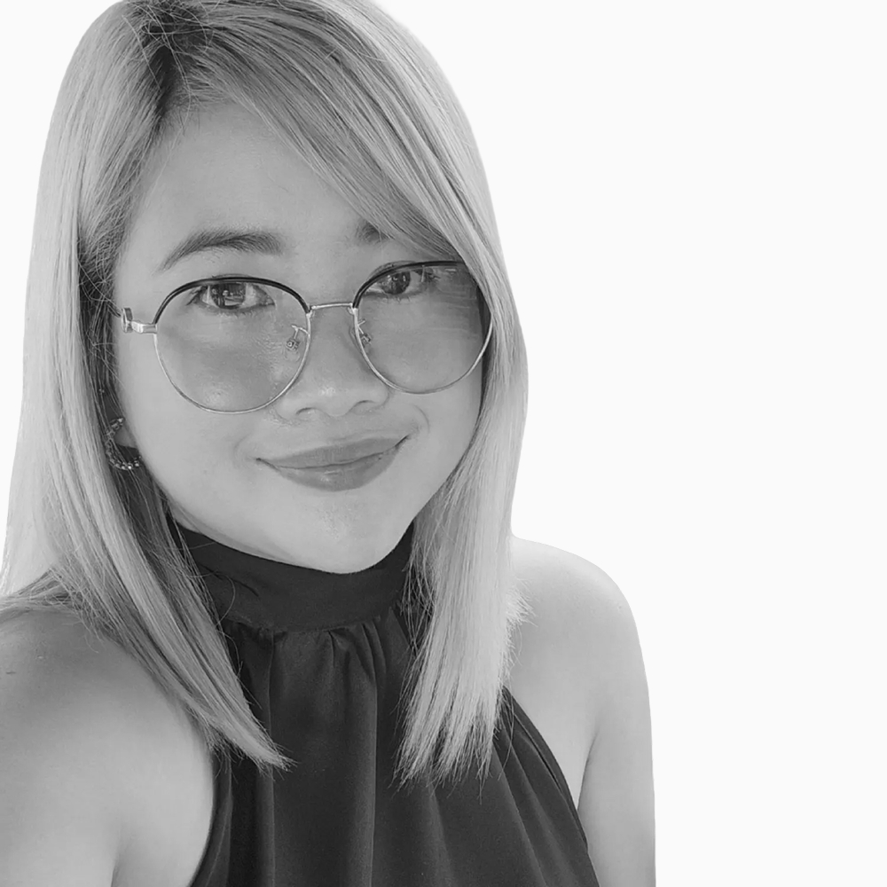 Professional black and white headshot of Ruby, Sales Operations Representative at Key Outreach, smiling while wearing round glasses and a sleeveless high-neck top against a light gray background.