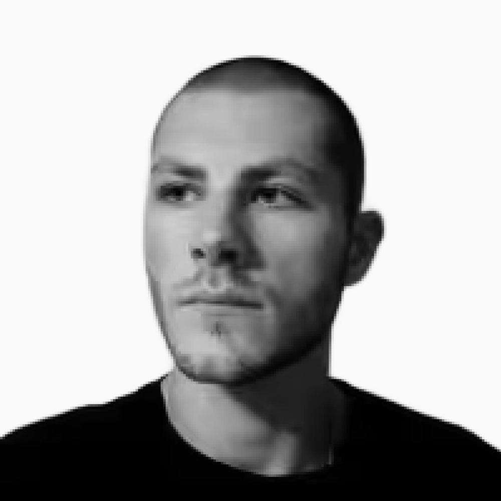 Professional black and white headshot of Joshua, Client Success Representative at Key Outreach, posing in a dark crew neck shirt while looking slightly to the side against a light gray background.