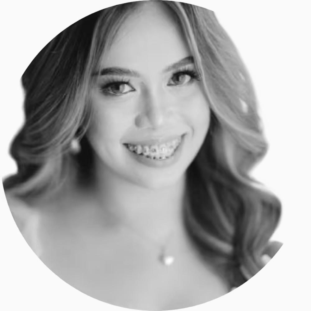 Professional black and white headshot of Xarren, Sales Operations Representative at Key Outreach, smiling while wearing braces, earrings, and a necklace with styled wavy hair against a light gray background.