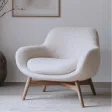 Modern white armchair with wooden legs on a light floor near a wall with artwork.